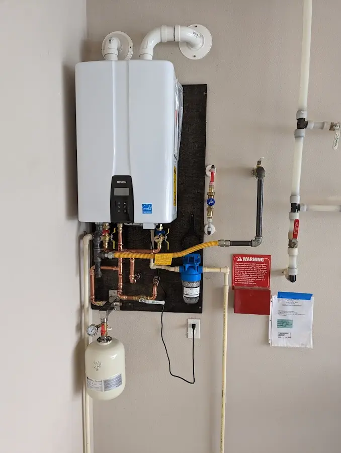 Professional plumber installing copper piping in a Le Roy home